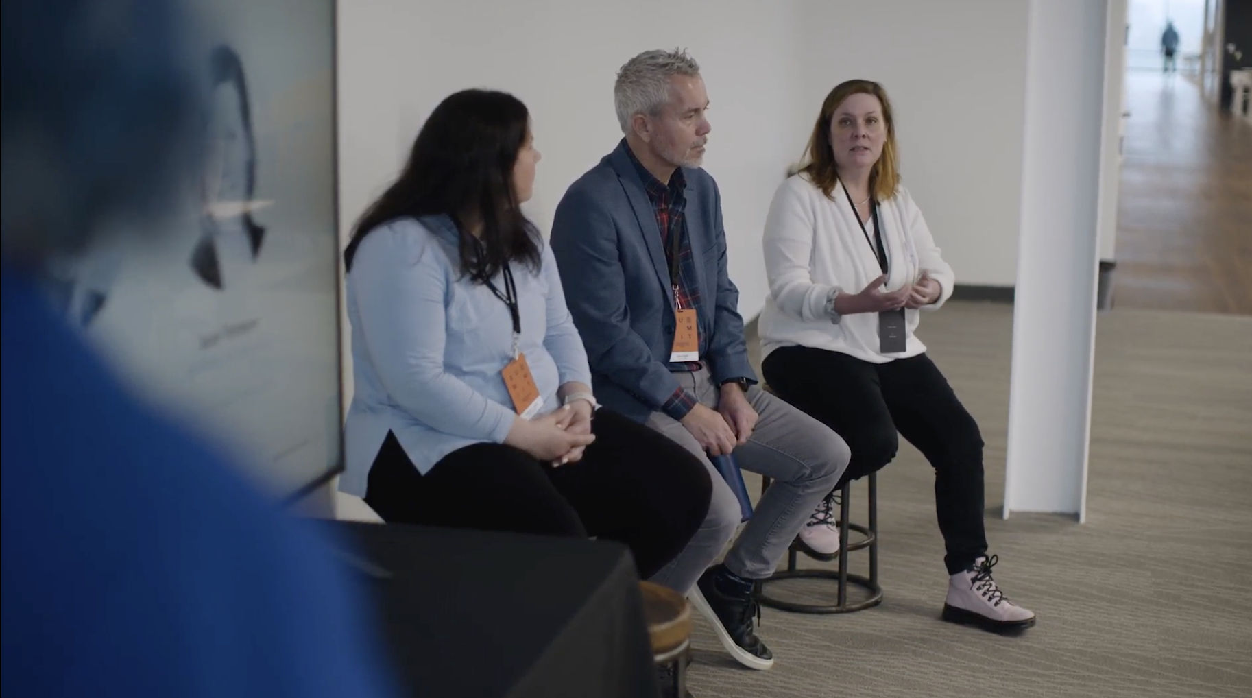 Image of 3 poeple in front of a 20 something audience talking
