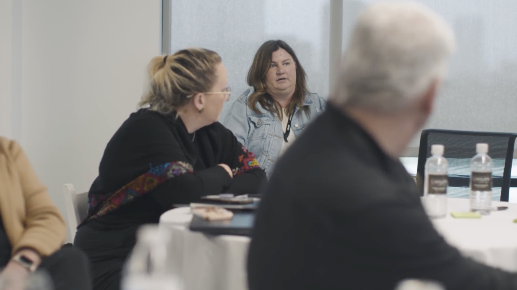 Image of 3 client sitting and listening to a presentation